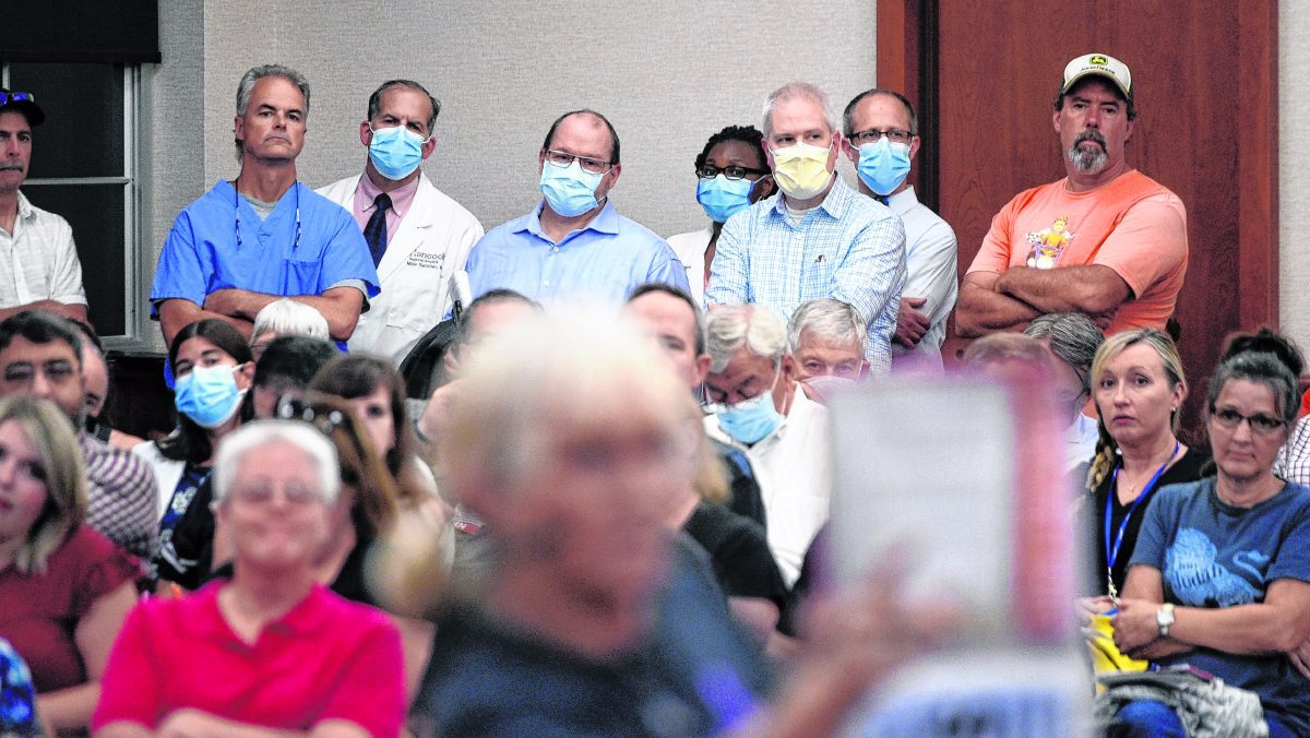 Members of the executive and medical staffs at Hancock Health listen to remarks from an attendee who was urging the county commissioners to approve a resolution opposing a vaccine mandate. (Tom Russo | Daily Reporter)