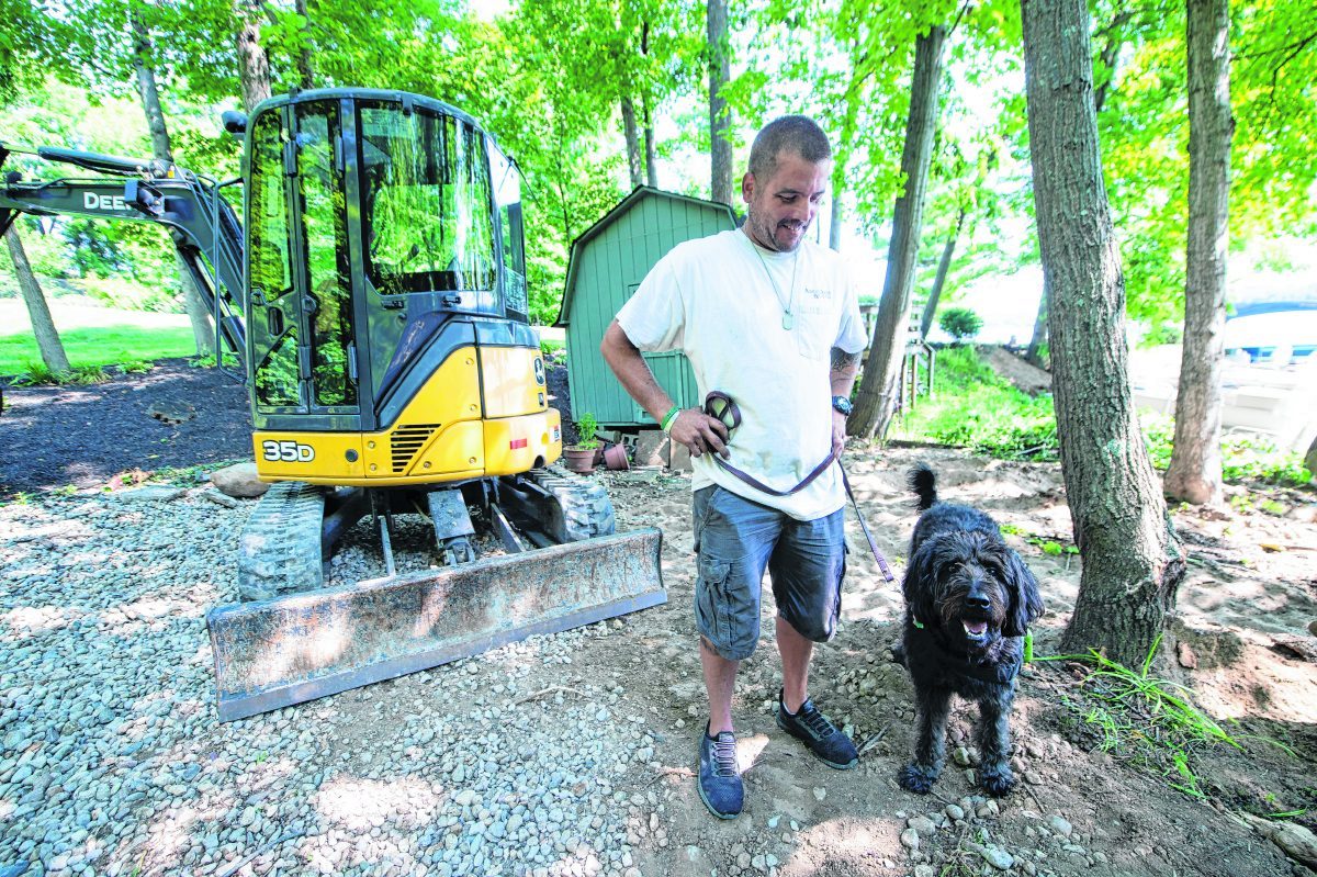 Donny Roberts works along with his support dog, Remy. Roberts participates in the SMART Recovery program, which organizers are trying to expand in Hancock County. (Tom Russo | Daily Reporter)